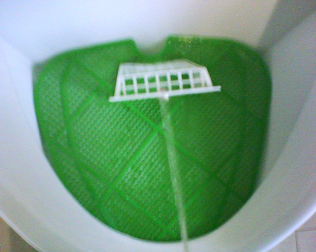 Eine Art Tor in einem Urinal zum Zielpinkeln.