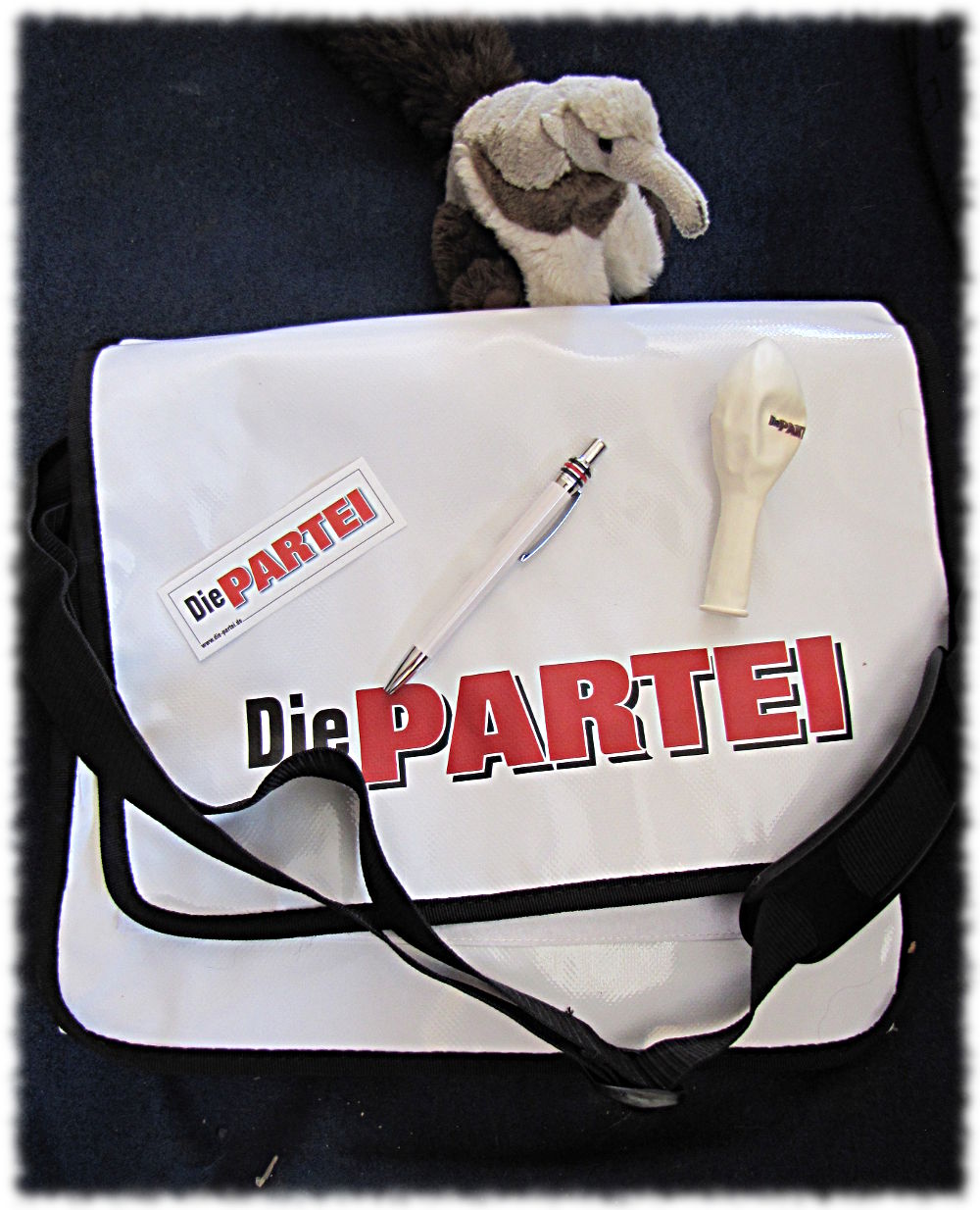 Tasche mit Logo der PARTEI, Aufkleber, Kugelschreiber, Luftballon und einem nicht dazugehörenden Stoffameisenbär.
