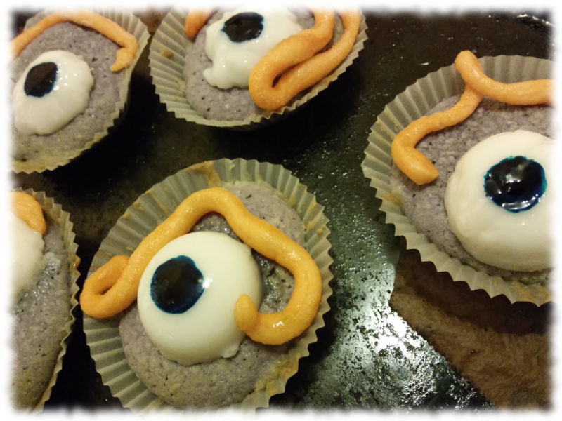 Grauviolette Cupcakes mit Marzipanwürmern und Augen aus gelierter Kokosmilch und Lebensmittelfarbe.